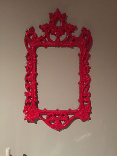 an ornate red frame hangs on the wall