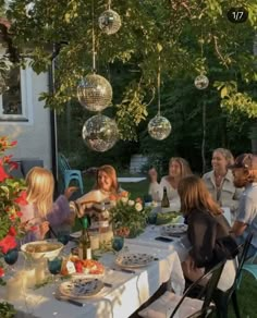 a group of people sitting around a table with food and drinks in front of them