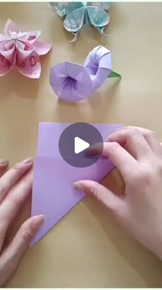 someone is making origami flowers out of paper