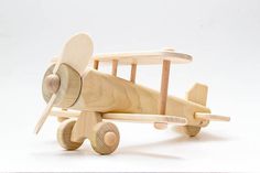 a wooden toy airplane sitting on top of a white table