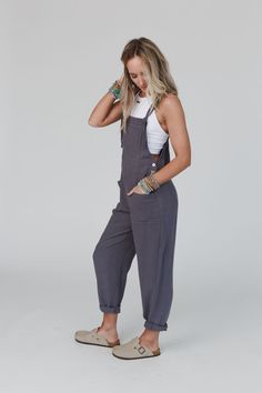 Stay comfy and boho-chic in our Dayton Tie Strap Overalls - these versatile overalls are sure to get compliments! Whether you're lounging at home or on-the-go, these overalls are sure to become a staple in your wardrobe because they feature: Comfortable, lightweight linen fabric Relaxed and loose overall silhouette Coconut button closure at sides Sleeveless design with adjustable self-tie straps Front patch pockets add a cute practical touch Go-to casual cute boho outfit pair with: Eye Of The Su Comfortable Overalls, Comfortable Practical Outfits, Womens Loose Overalls, Easter Party Outfit, Cotton Overalls Outfit, Comfy Overalls, Comfortable Summer Outfits Casual, Casual Non-stretch Overalls, Everyday Cotton Overalls