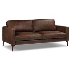 a brown leather couch sitting on top of a white floor