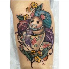 a tattoo on the leg of a woman with a mouse sitting in a teacup