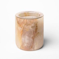 a marbled candle holder on a white background with the light reflecting off of it's surface