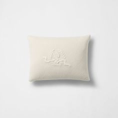 a white pillow with embroidered logo on it