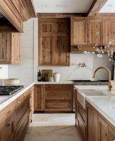 a kitchen filled with wooden cabinets and white counter tops next to a stove top oven