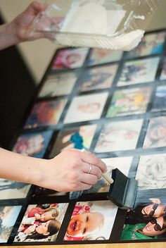 a table with many pictures on it and someone holding a small object in their hand