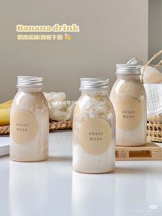 three jars with labels on them sitting on a counter top next to bananas and other items