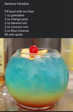 a blue and yellow drink with a cherry on the top, in a glass bowl