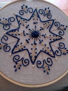 a blue and white snowflake is shown in the hoop on a table top