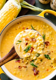 a spoon full of soup with corn on the cob