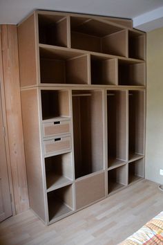 an empty closet with drawers and shelves on the wall next to a bed in a bedroom