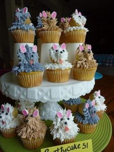 cupcakes with frosting and decorations are arranged on a cake stand