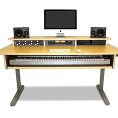 a computer desk with keyboard, monitor and two speakers on top of it in front of a white background