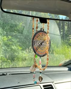 a car dashboard with beads hanging from it's dash board and the sunroof