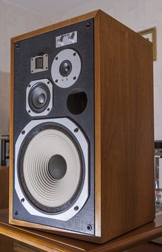 a speaker sitting on top of a wooden table