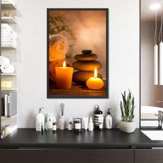 two candles are lit in front of some rocks on the counter with other items around it