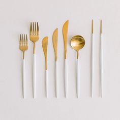 gold and white utensils lined up in a row