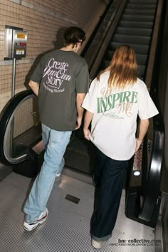 two people are walking up an escalator