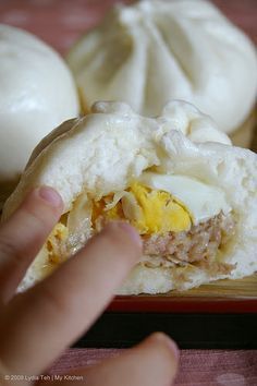 a person is holding an egg and bread sandwich