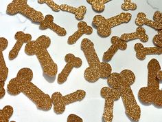 gold glitter dog bone shaped confetti on a white table