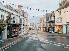 an empty street with shops on both sides and bunting strung across the street from buildings