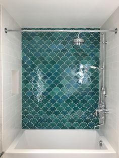 a bath tub with a shower head and hand held faucet