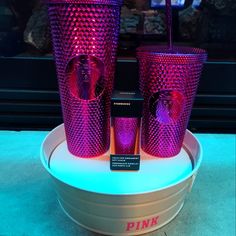 three pink glass cups sitting on top of a table