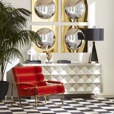 a living room filled with furniture and mirrors on the wall next to a potted plant