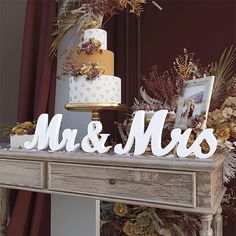 a table topped with a cake next to a couple's initials on top of it