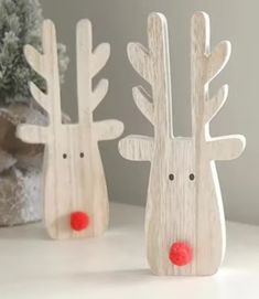 two wooden reindeer figurines sitting next to each other