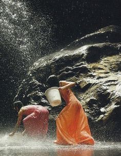 two people in the water with buckets on their heads