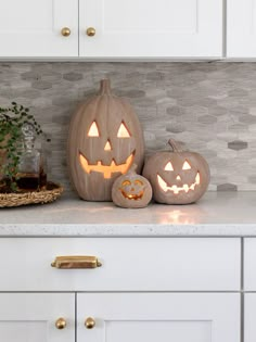 two carved pumpkins sitting on top of a kitchen counter