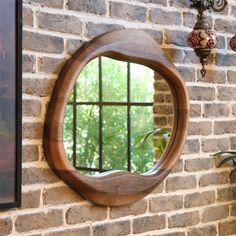 a round mirror mounted to the side of a brick wall