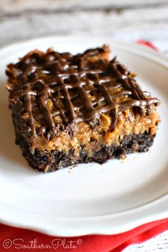 a piece of chocolate peanut butter bars on a white plate with a red and white napkin