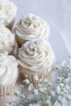 cupcakes with white frosting sitting on a glass plate