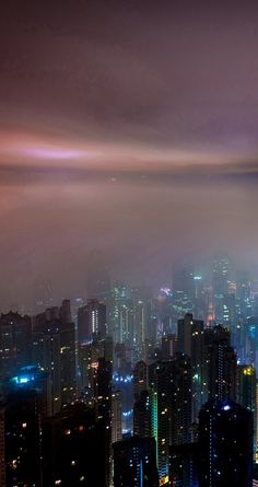 an aerial view of the city at night with skyscrapers lit up in bright colors