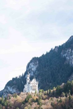 a castle on top of a mountain with trees in the foreground