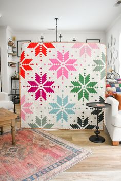 a living room filled with furniture and a large quilt