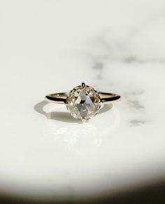 a close up of a diamond ring on a white surface with the light shining through it