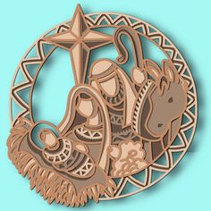 an ornament depicting the birth of jesus in wood cutout style on a blue background