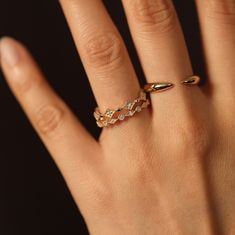 a woman's hand with a gold ring on it and diamond band around the middle