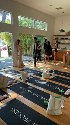 yoga mats are laid out on the floor with people standing around and looking at them