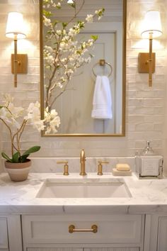 a bathroom sink with a mirror above it and flowers in a vase on the counter