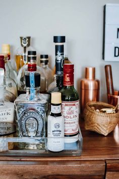 bottles of alcohol sit on top of a wooden table