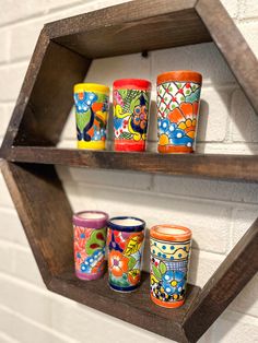 wooden shelves with colorful painted cups on them