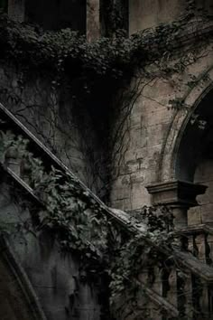 an old building with ivy growing on the side and stairs leading up to it's entrance