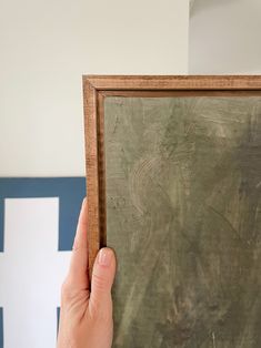 a person holding up a painting in their hand