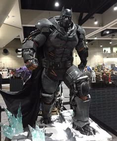 a man dressed as batman stands on display