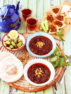 two bowls filled with food sitting on top of a table next to other foods and drinks